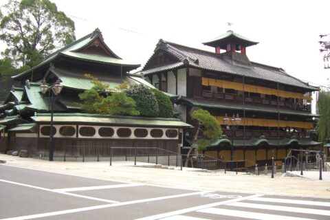 「北東から見た道後温泉本館」：振鷺閣から打ち鳴らされる刻太鼓（ときだいこ）が、1996年(平8成年)に残したい日本の音風景100選」に選定された。（愛媛県松山市）