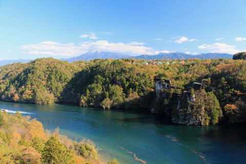 恵那峡大橋の上流右岸に隣接する展望台から望む恵那峡（左：獅子岩と右：将軍岩、岐阜県中津川市）と遠景の恵那山