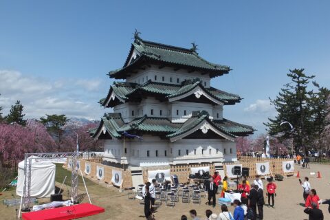 ​2016年春の弘前城天守閣。天守の耐震補強工事と石垣の補強工事のために2015年秋に曳家工事が行われ、仮の天守台の上に移動された。天守の彼方には岩木山を望む。