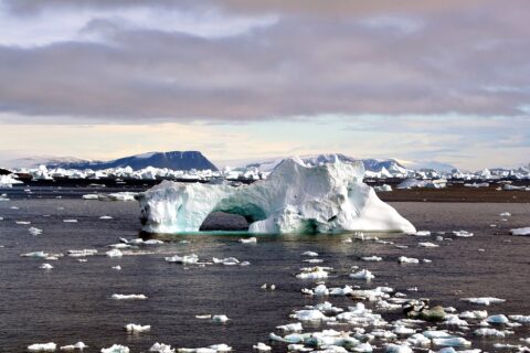 Icebergs around Cape York,Greenland. The icebergs are beautiful and display many interesting shapes. You could see the iceberg with a hole at the image. The hole was caused by weathering effects - erosion by waves, wind