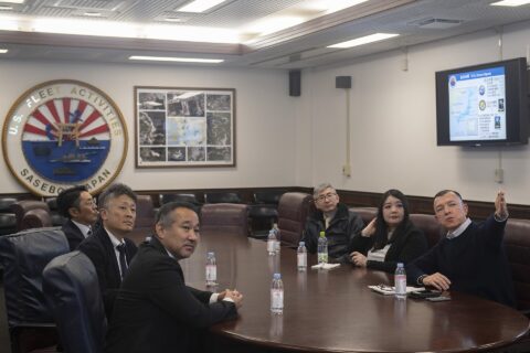 Commander, Fleet Activities Sasebo (CFAS) Public Affairs Officer Aki Nichols, right, gives a command brief to Mayor Takashi Kojima of Shintomi Town, Miyazaki Prefecture, and his staff after an office call at CFAS Headqua