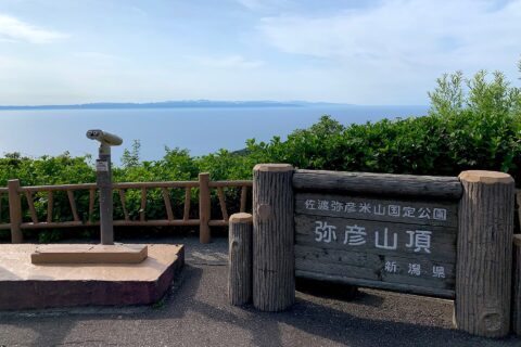 ​弥彦山山頂駐車場付近から佐渡島を望む（2020年6月）山頂の看板が随所にあるがここは9合目である。