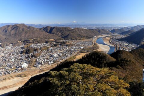 岐阜城の復興天守展望台から望む北東側の風景、岐阜県岐阜市にて、長良川の右岸に岐阜県道94号岐阜美濃線、左岸に岐阜県道287号上白金真砂線、岐阜県道77号岐阜環状線の鵜飼い大橋が交差する、遠景は百々ヶ峰、乗鞍岳、御嶽山、木曽山脈などの山並