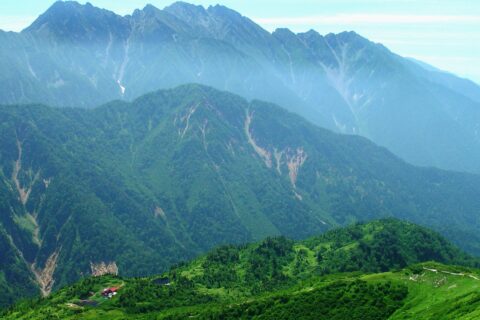 小池新道新道から見下ろす鏡平山荘、遠景は奥丸山と穂高岳