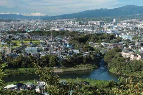 静岡県清水町を流れる清流柿田川。右手前で狩野川と合流する。左中段端の森が柿田川の源流。沼津市の本城山から撮影。