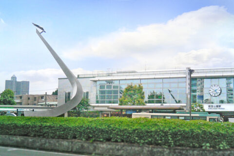 航空公園駅東口 3 階建ての駅ビル全体が複葉機 アンリ・ファルマン号をイメージした特徴的なデザインになっており、1998年 関東の駅百選にも選定されている。遠景に見えるのは所沢市街地元町の高層マンション「フォーラスタワー所沢」