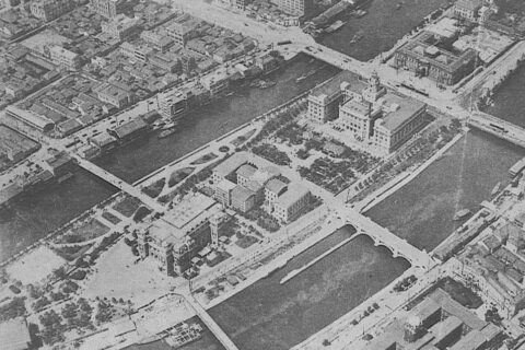 Nakanoshima and its park, part of which is seen towards the left in the central delta. The first building at the extreme left in the delta is the public Hall, followed in order toward the right by the city public library