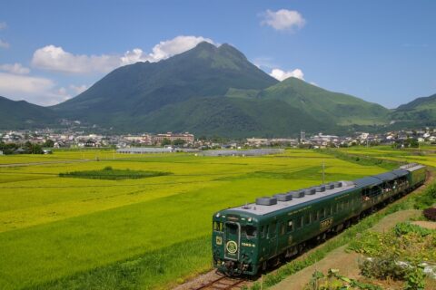 JR九州久大本線のTORO-Q、由布院駅～南由布駅間にて撮影。 総合運動公園の近い一般道の跨線橋からの撮影です。後方は南西から見る由布岳。