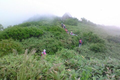 白神岳の山頂近くを歩く登山者